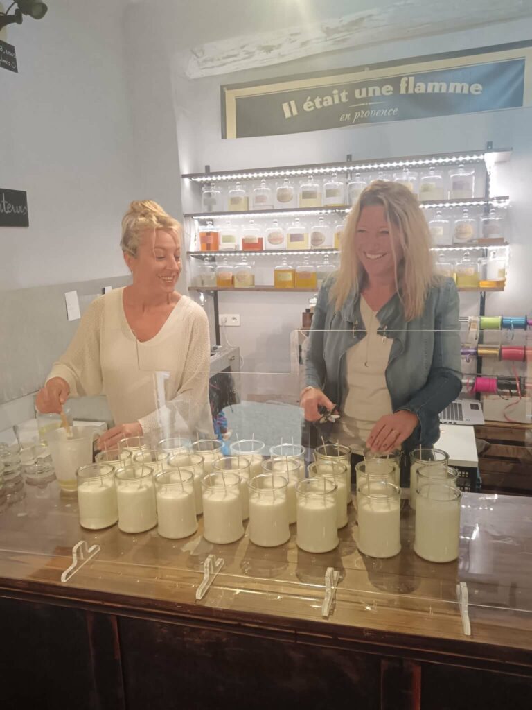 Noëllie et Céline en pleine fabrication artisanale d’une bougie parfumée dans l’atelier à Roussillon.